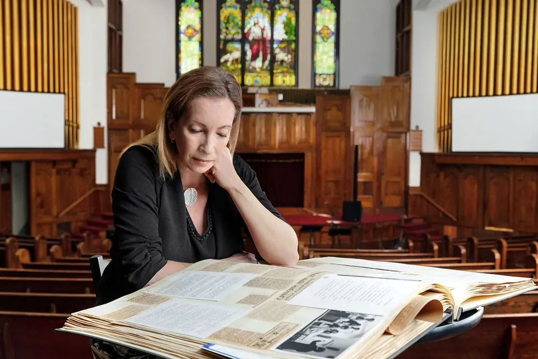 Emily Stokes looks at archival book of newspaper clippings.